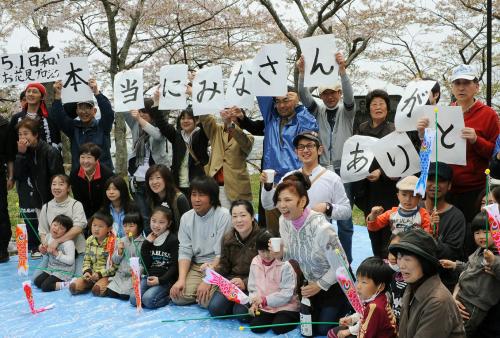 宮城県石巻市の日和山で行われた花見に、飛び入り参加した歌手の八代亜紀さん（前列右から３人目）と記念写真に納まる市民ら