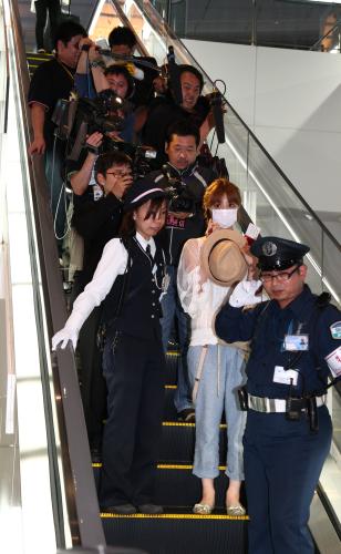 報道陣に追われ空港内を移動する小倉優子