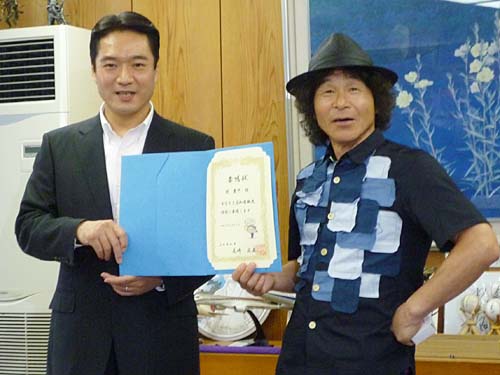 尾崎高知県知事（左）から高知県観光特使の委嘱状を受け取る間寛平
