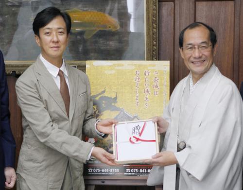 京都市役所を訪れ、二条城修復のための寄付金を門川大作市長（右）に手渡す歌舞伎俳優の坂東玉三郎