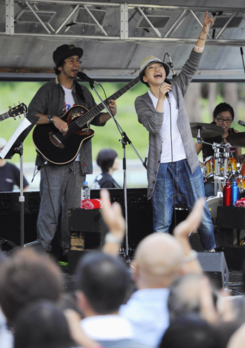 ライブで被災者らに手を振る「ドリームズ・カム・トゥルー」の吉田美和さん（右）と中村正人さん