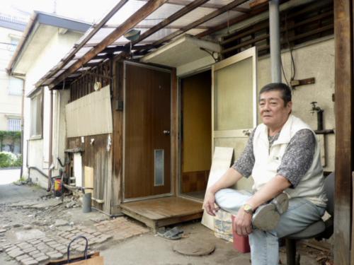 老朽化のため、立て直し工事が始まった「尾崎ハウス」。右手前は小峰忠雄さん
