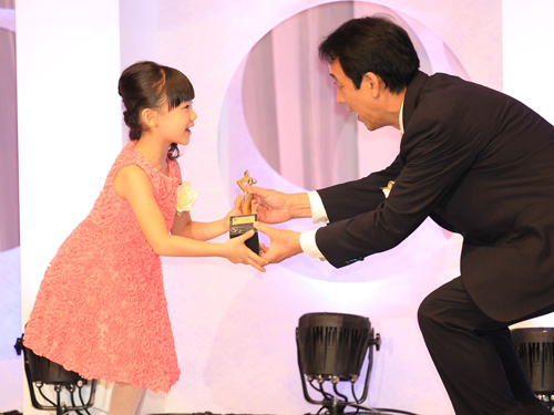 主演女優賞の芦田愛菜（左）にプレゼンターの川端総務相はしゃがんでトロフィーを渡す