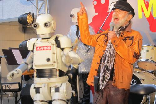 映画「ロボジー」の主題歌を熱唱したミッキー・カーチスと、劇中に登場するロボットの「ニュー潮風」