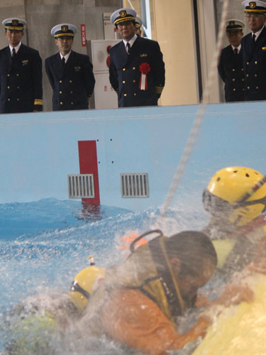 海上保安庁の特殊救難隊による海面吊り上げ救助訓練を見守る杉良太郎（左から３人目）