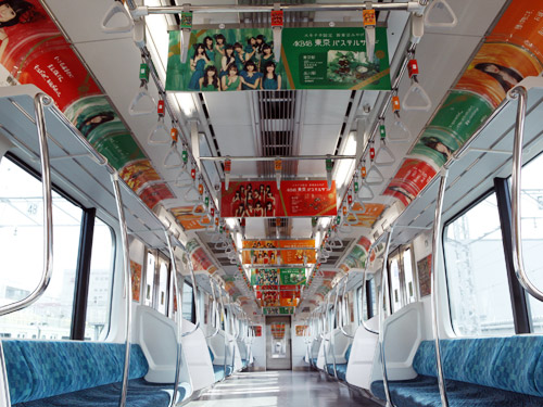 山手線の限定車両として走っているアドトレインの車内。ＡＫＢ４８がイメージキャラクターを務める東京限定お土産の「東京パステルサンド」の広告が並ぶ