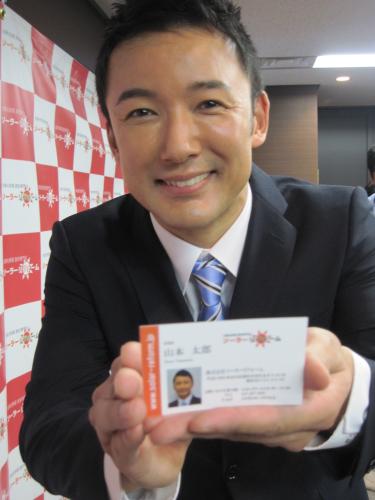 株式会社ソーラーリフォームの入社式に出席した山本太郎はできたての名刺を差し出す