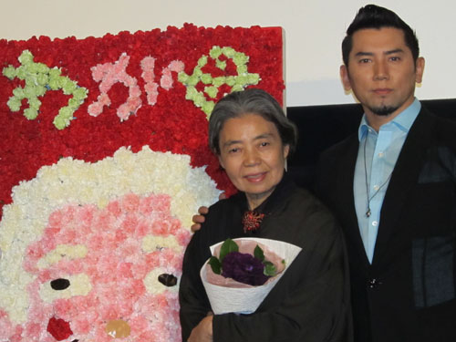 樹木希林と本木雅弘は映画「わが母の記」の舞台あいさつに出席。カーネーションで作られた希林の“花絵”を背に笑顔