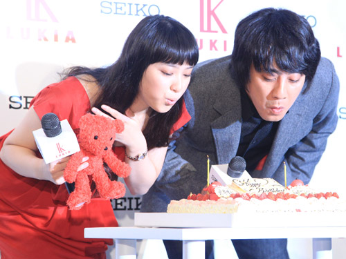 １２月生まれの武井咲と山崎まさよしが、プレゼントされたケーキのロウソクの火を仲良く吹き消す