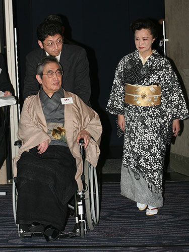 ２００６年、日本映画監督協会７０周年パーティーに歴代理事長の紹介で小山明子夫人（右）に付きそわれて登壇した大島渚監督
