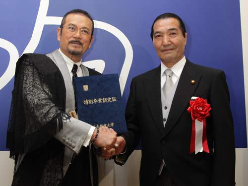 日体大の卒業式で同大の松浪健四郎理事長（右）と握手する千葉真一