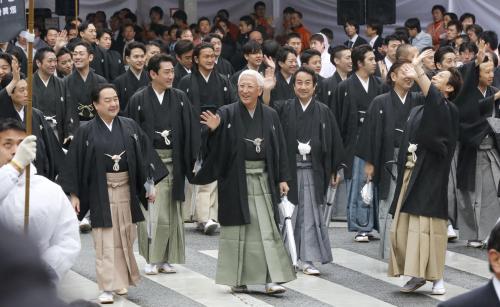 　歌舞伎座の再開場を記念したお練りで、沿道のファンに手を振る中村時蔵（中央）ら歌舞伎俳優