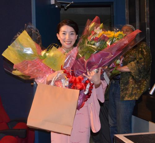 映画「出逢いが足りない私たち」の初日舞台あいさつで、ファンから両手いっぱいの花束をプレゼントされる嘉門洋子