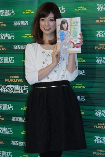 「小倉優子の毎日ほめられごはん」発売記念イベントで、レシピ本を手に微笑む小倉優子