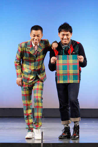 伊勢丹柄の新スーツをお披露目したＣＯＷＣＯＷの多田健二（左）と、新しくなった伊勢丹の紙袋を手にする相方の善