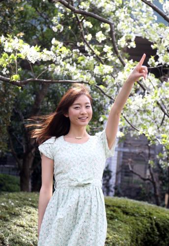 お天気キャスターに決まった新井恵理那は、咲き乱れる花を背に笑顔