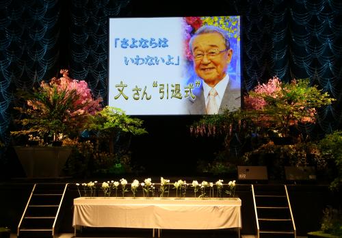 山本文郎さんの写真が写し出された引退式のステージ