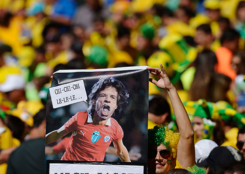 ６月２８日の決勝トーナメント１回戦チリ戦で、チリのユニホーム姿のミック・ジャガーの写真を掲げるブラジルサポーター（ＡＰ）