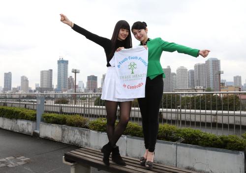 活動の拠点となるシンガポールに似ているという本社からの景色を背にポーズをとる新井寿枝さん（右）と貴子さん姉妹