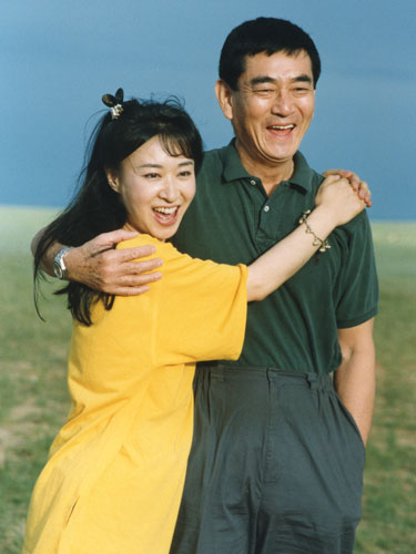 ８９年に「日本映画使節団」として中国を訪れた健さんと三田佳子。大草原で肩を抱き合う（三田佳子提供）