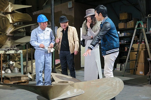 プロペラ修理工場を訪問し説明を聞く（右から）東貴博、萬田久子、前田吟