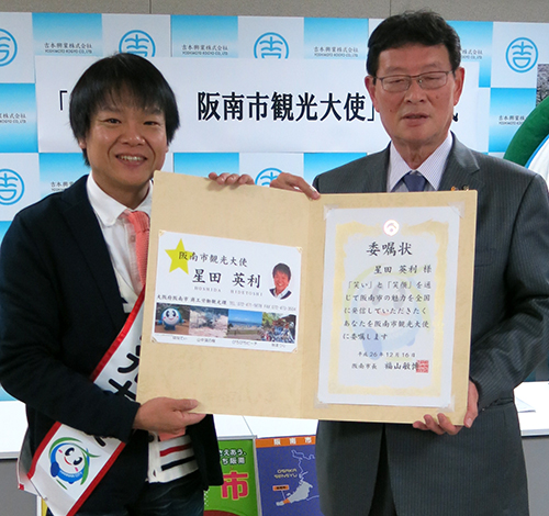 会見で笑顔をみせる星田英利（左）と福山敏博阪南市長