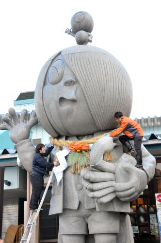 特大しめ飾りが取り付けられた「ゲゲゲの鬼太郎」の巨大石像＝25日、鳥取県境港市