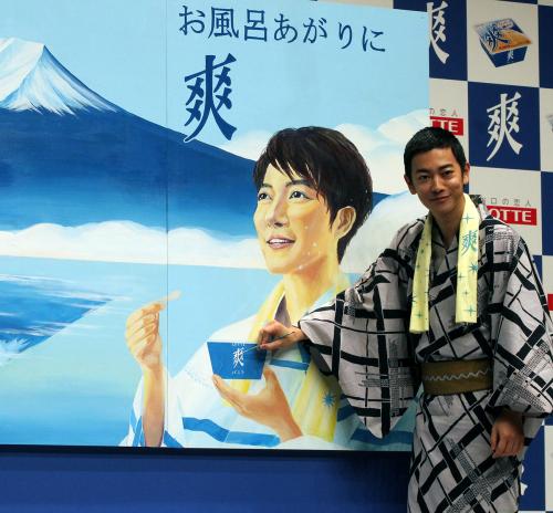 銭湯に描かれた自身と富士山の絵をバックに笑顔を見せる佐藤健