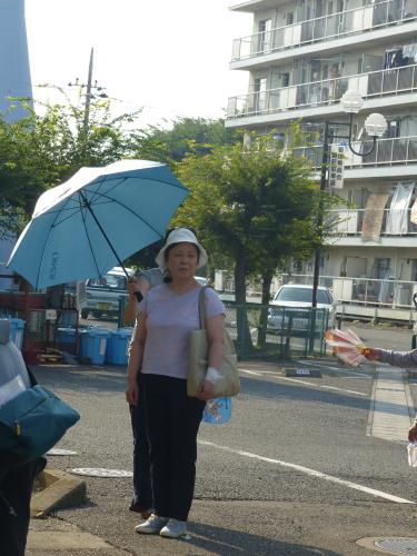 猛暑の中、日傘に隠れて出番を待つ藤山直美