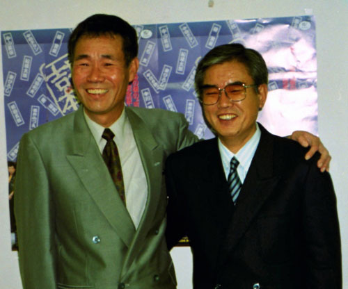 ９２年、２人会開催会見で笑顔で肩を組む岡八郎さん（左）と花紀京さん