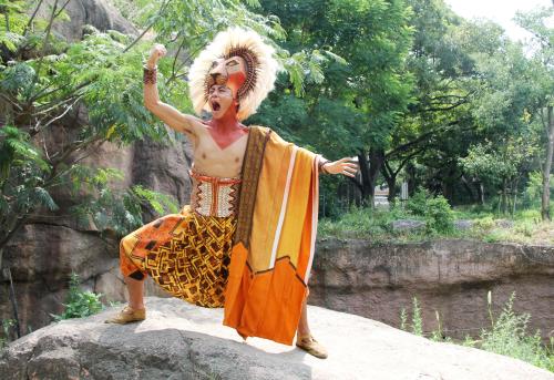 天王寺動物園のライオンの飼育ゾーンで、ポーズを決める「シンバ」役の石毛翔弥