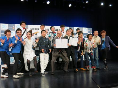提携協定に調印した大阪観光局・溝畑宏局長（左から５人目）、吉本興業・戸田義人副社長（同６人目）とお笑い芸人ら
