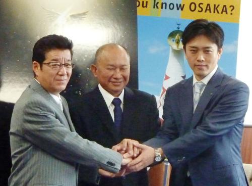 大阪で撮影予定の新作映画について報告に訪れたジョン・ウー監督（中央）と握手する、松井一郎知事（左）と吉村洋文市長（右）