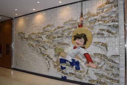秋田空港に飾られた「釣りキチ三平・山魚女（やまめ）群泳」の巨大壁画