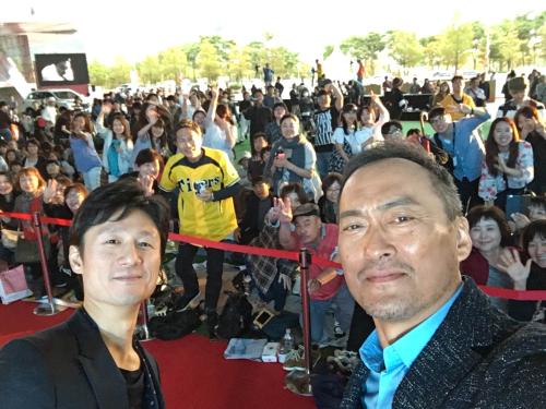 釜山国際映画祭のトークイベント後、ファンをバックに記念撮影する渡辺謙（右）と李相日監督