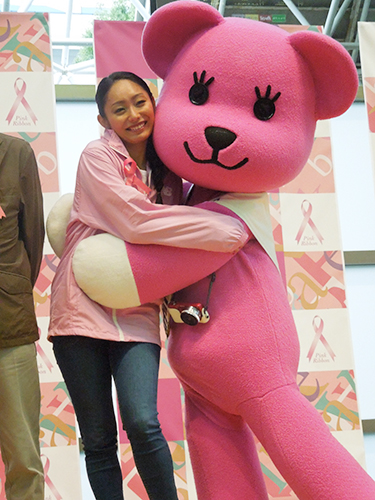 ピンクリボン運動の公式キャラクターと抱き合って乳がん検診の大切さを訴える安藤美姫