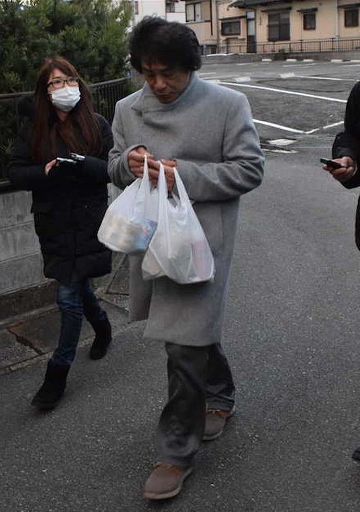 福岡の実家前で報道陣の取材に応じるＡＳＫＡ。缶コーヒーの入った袋を手にウオーキングから帰宅