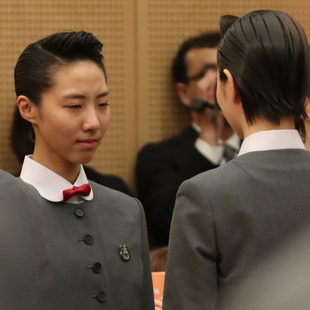 宝塚音楽学校入学式で、校章をつけてもらい、涙をみせる松岡恵さん（左）