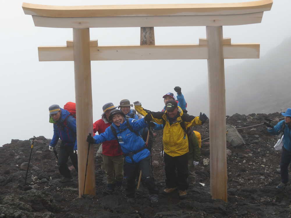 富士山山頂にある富士山本宮浅間大社の鳥居をガッツポーズでくぐる桂文枝（中央）