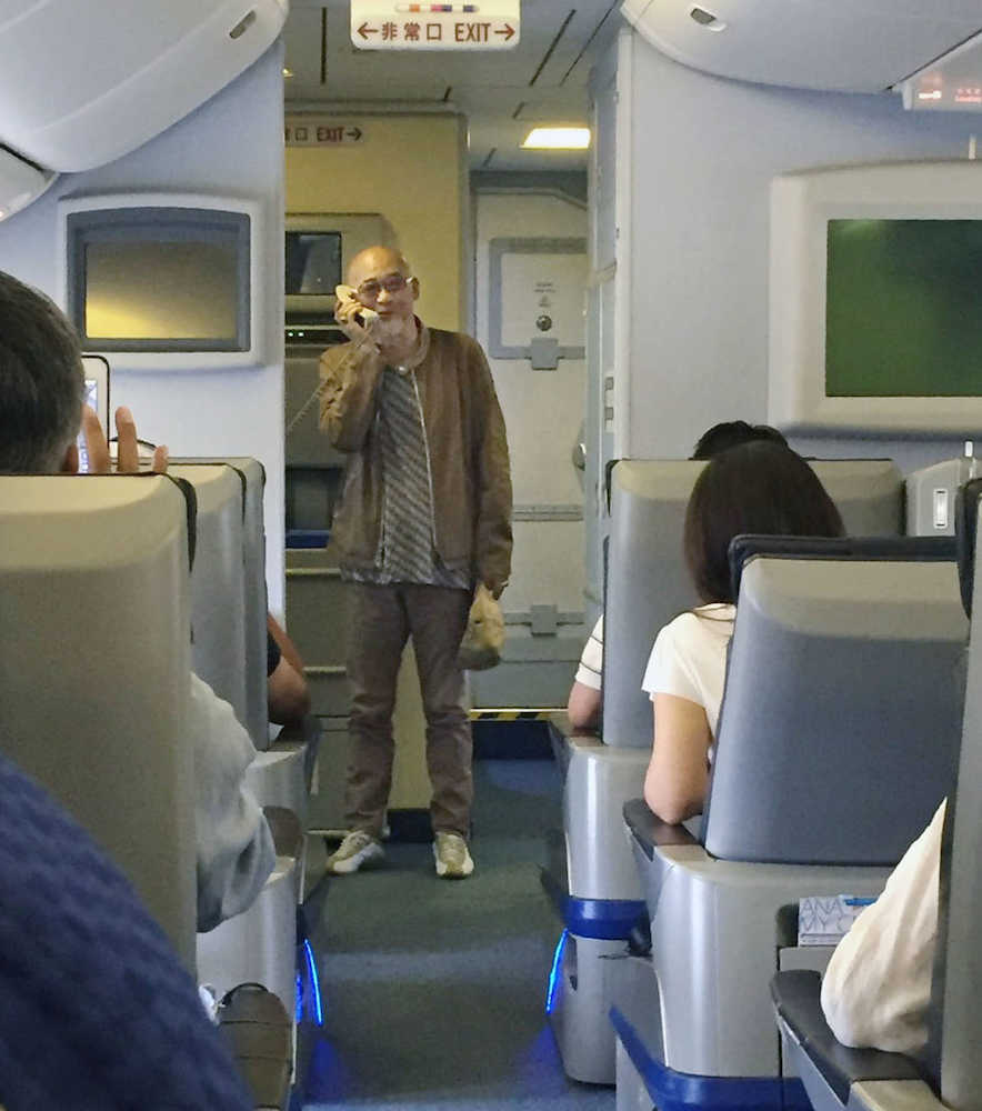 ２０日、Ｕターンラッシュによる保安検査場の混雑で出発が遅れた全日空機内で、代表曲「大空と大地の中で」を披露した歌手の松山千春（乗客提供）