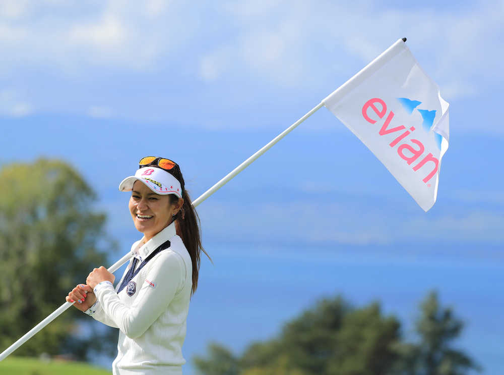 練習ラウンドを終えた宮里藍はレマン湖を背に旗を担いで笑顔