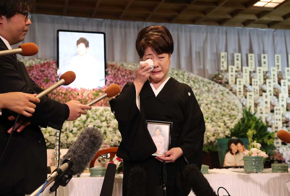 母・久子さんの遺影を手に報道陣の質問に答えながら涙する川中美幸