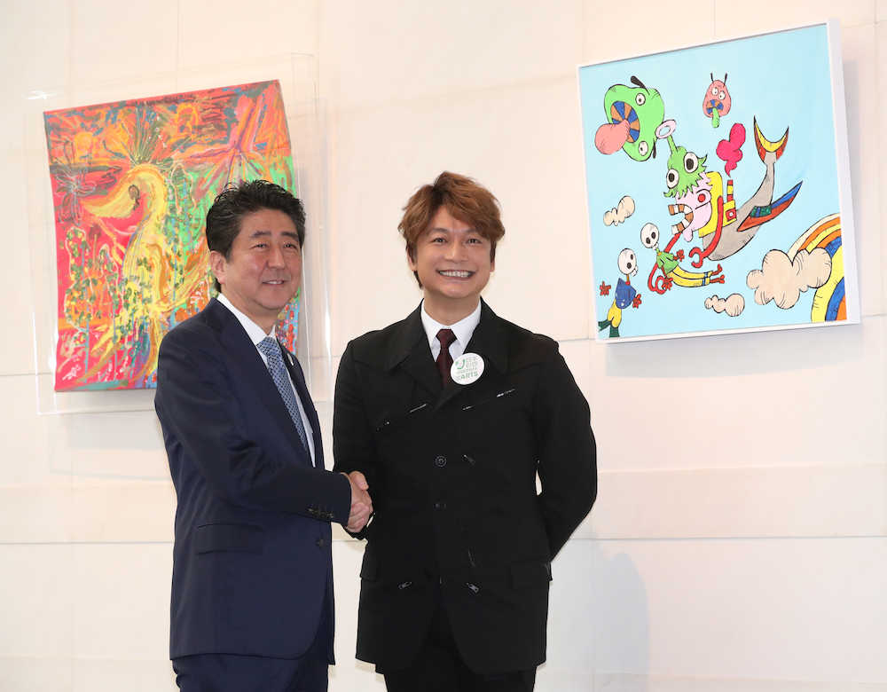 展示された自身の作品の前で安倍首相（左）と笑顔を見せる香取慎吾