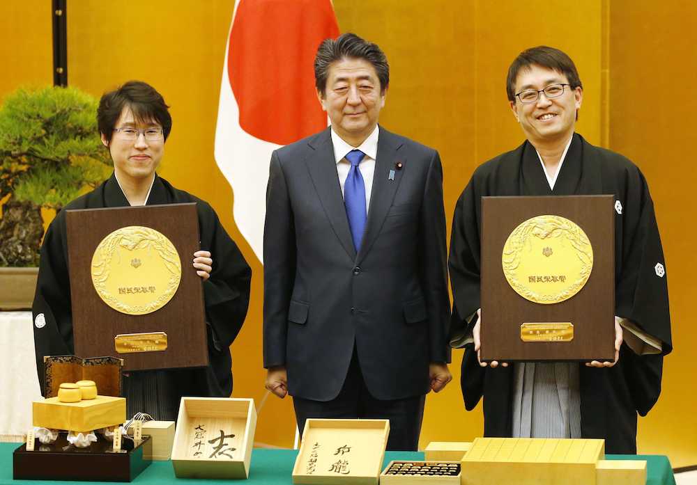 国民栄誉賞を授与され、安倍首相とともに記念撮影する囲碁の井山裕太氏（左）と将棋の羽生善治氏