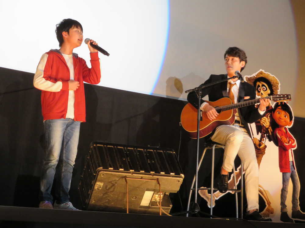 大阪市内で行われたアニメ映画「リメンバー・ミー」の舞台あいさつに日本語吹き替え版で主人公のミゲル役の声優を務めた石橋陽彩（左）の主題歌生披露にあわせ、ギターの生演奏を行う藤木直人