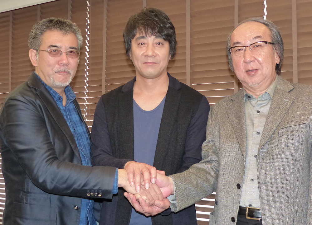 手をがっちりと握る（左から）篠原哲雄監督、山崎まさよし、横山秀夫氏