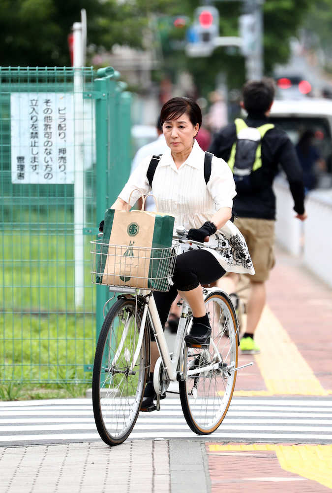 証拠品を紙袋に入れ、自転車に乗り北沢警察署を訪れた松居一代（撮影・　久冨木　修）