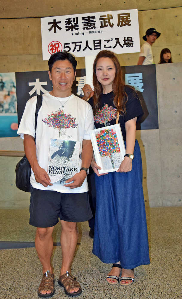 「木梨憲武展」の５万人目の来場者となった大阪市西区の夏山純也さん（左）、岡恭子さん