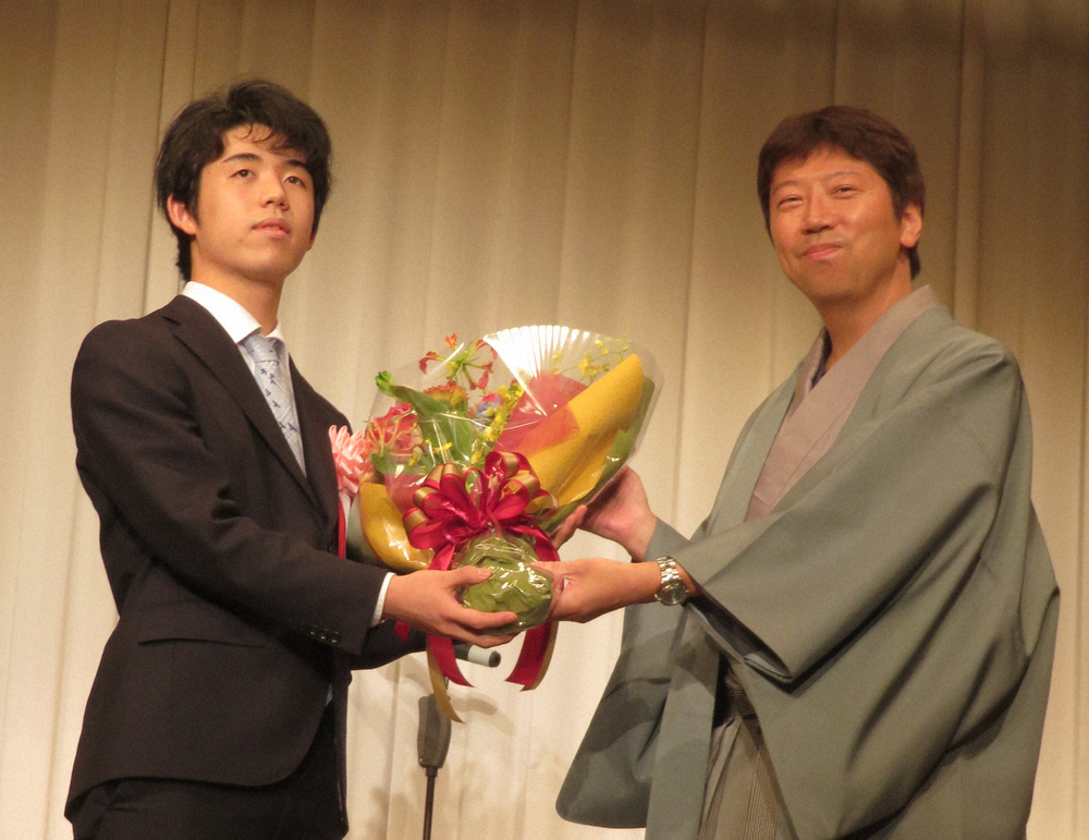杉本八段（右）の昇段・昇級を祝う会に出席し、花束を贈呈する藤井七段