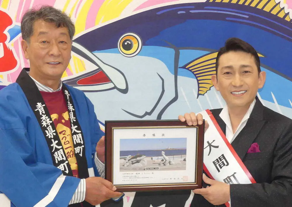 観光大使の委嘱状を野崎尚文町長（左）から手渡される福田こうへい